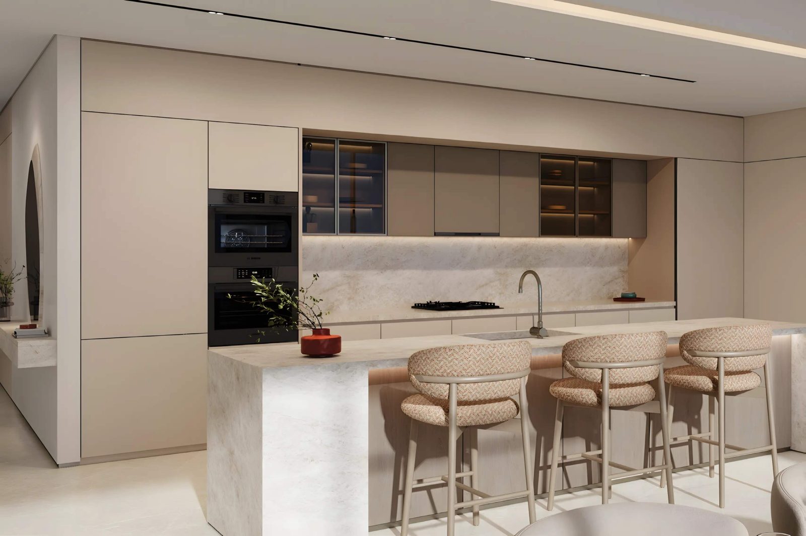 Kitchen at SOMA Residences with a stone island, bar stools and integrated ovens