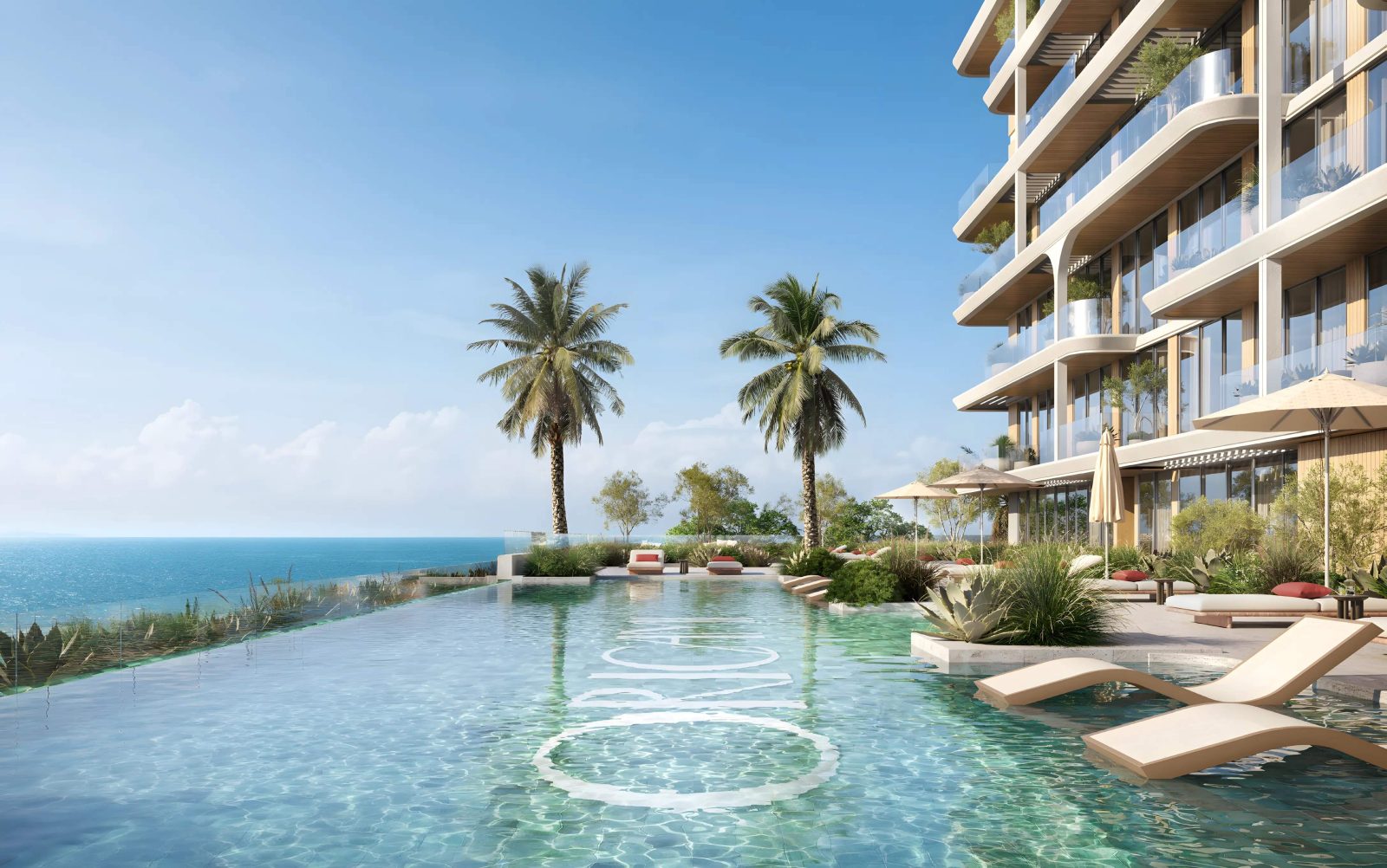 Swimming pool at SOMA Residences with palm trees, loungers and the open sea beyond